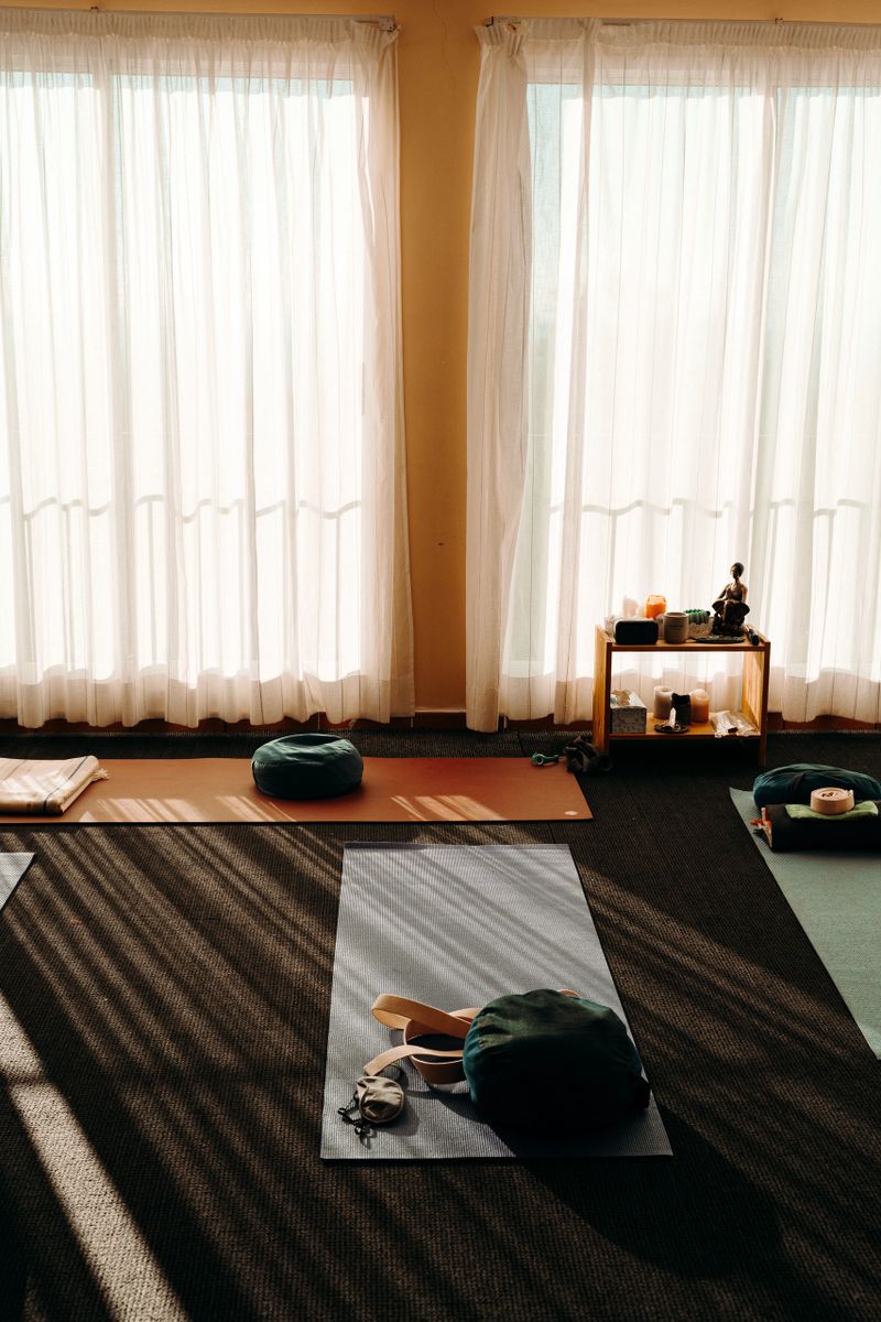 Yoga room with yoga pads,pillows, others accessories for relaxation and a table with scented Zen candles for meditation or peace of mind