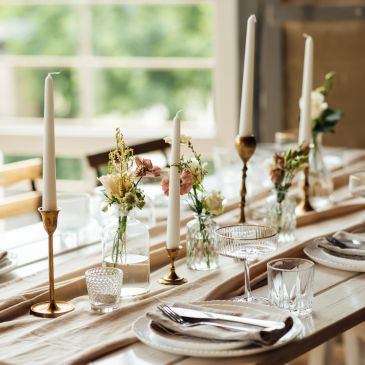Elegant dining table with candles and floral arrangements.