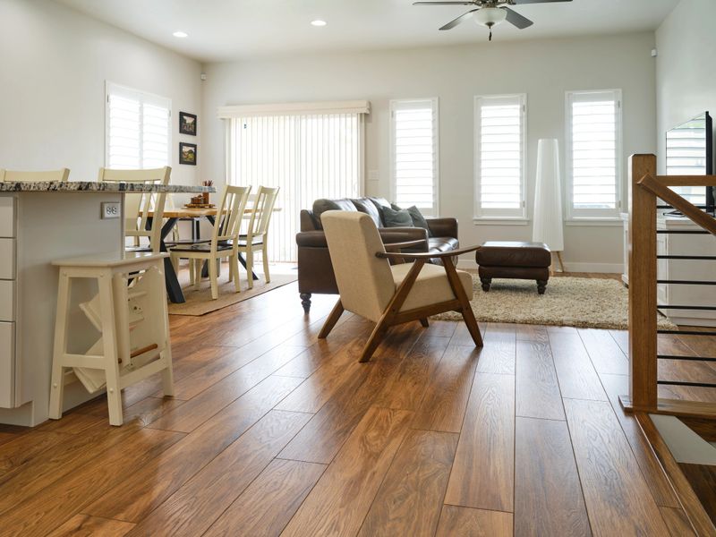 A home interior ‘great room’, featuring hardwood floor and white kitchen cabinets.