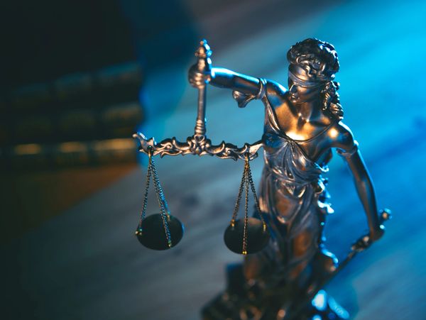 A bronze Lady Justice statue holding scales symbolizing fairness.