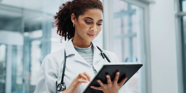 Female doctor using a digital tablet in a modern medical facility.