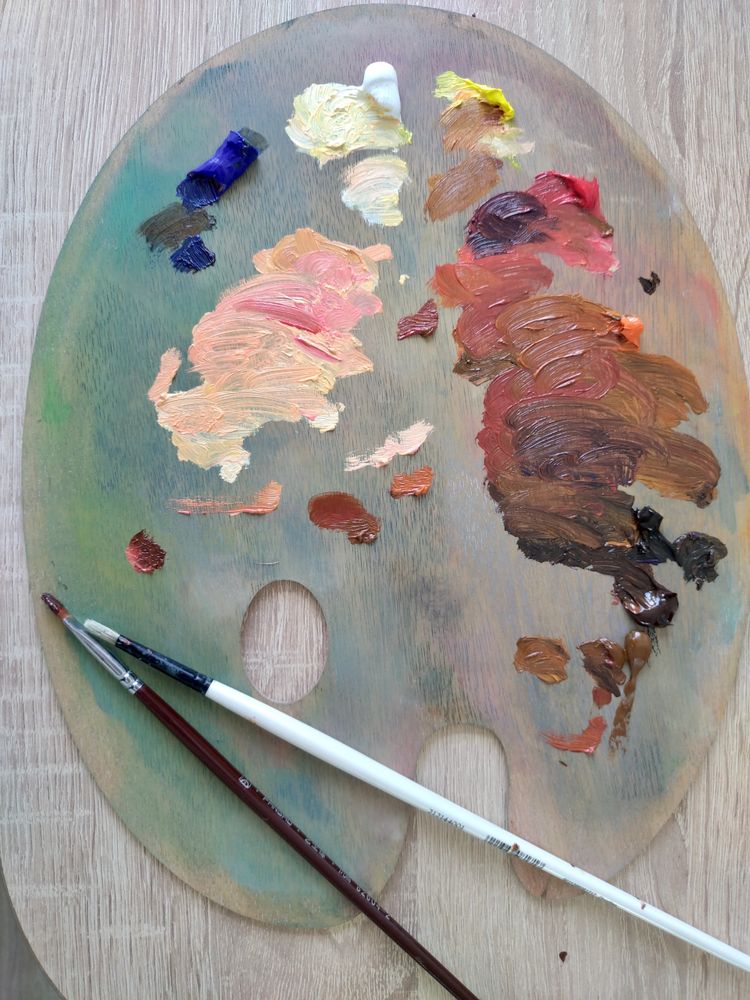 Stack of books next to pencils in a holder and a camera.