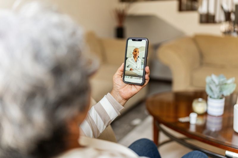 Senior woman talking on video call during telemedice at home
