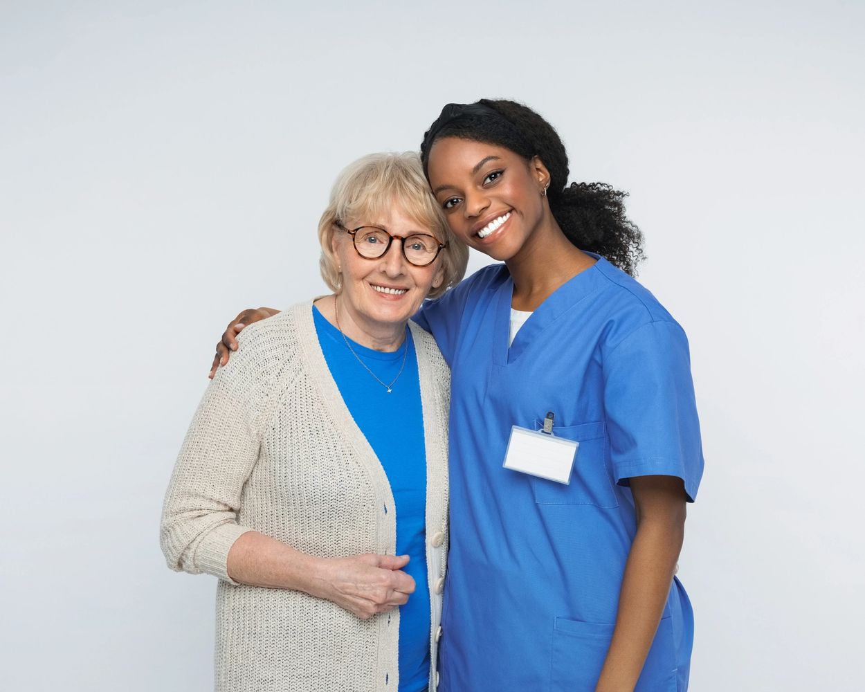 A nurse and elderly woman smiling together, showing care and support.