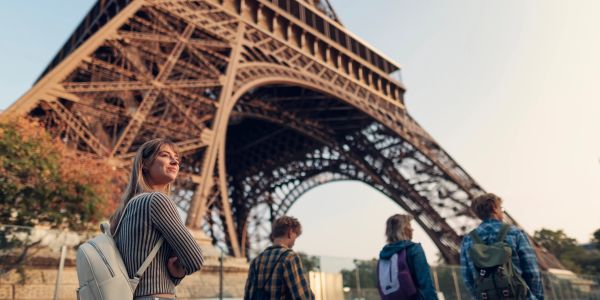 Tourists exploring near the Eiffel Tower at sunset.