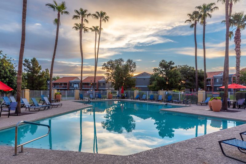 The sunrise reflects off the still waters of an apartment complex's community pool.