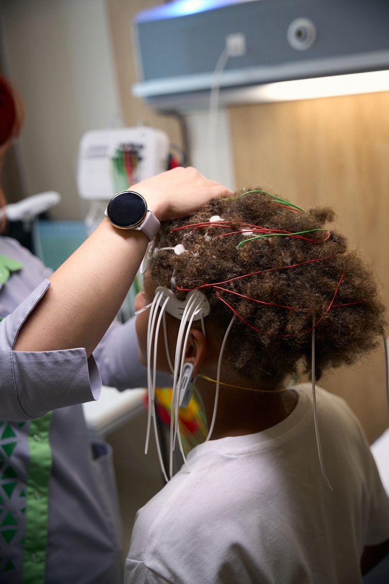 Medic carefully positions EEG electrodes on a young patients scalp to ensure proper placement for accurate brain activity monitoring