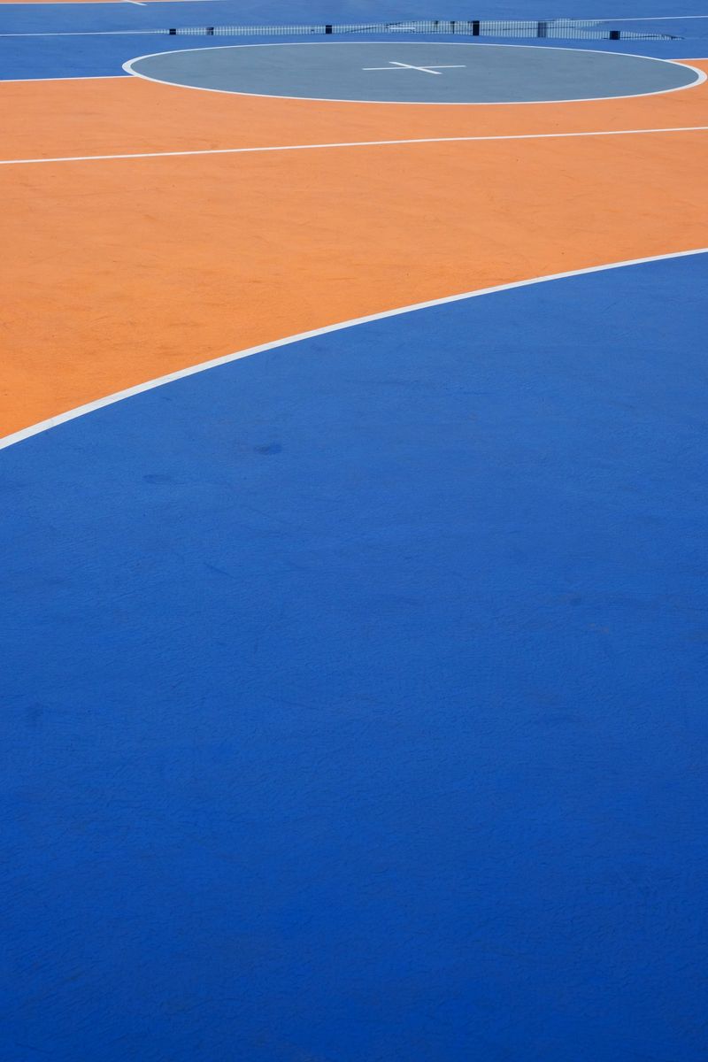 Colorful outdoor sports court with blue and orange sections.
