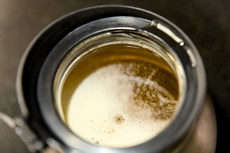 Close-up of a freshly poured craft beer, frothing with golden bubbles Ghee.
