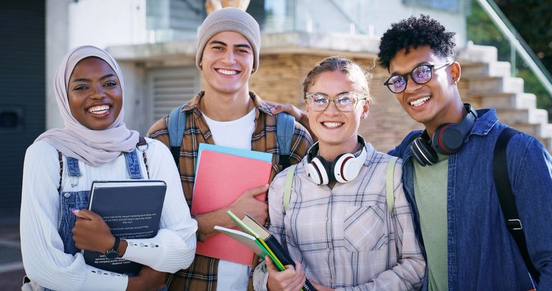 Students, smile and portrait at university for education, diversity and friendship on campus. People, academic or happy with books for about us, group project team or excited for learning development