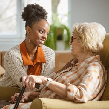 Two people sitting on a sofa. Care giver