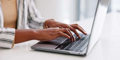 Person typing on a laptop keyboard.