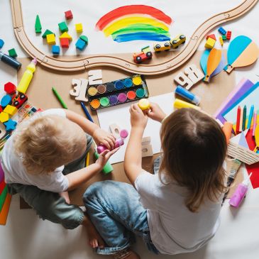 Two children painting and playing with toys.
