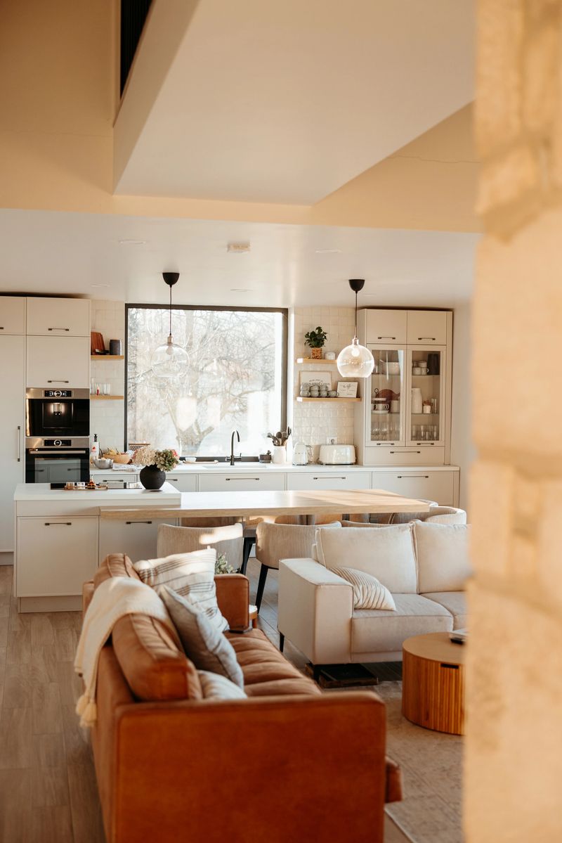 Sunlight streaming through the windows of an open concept kitchen and living room