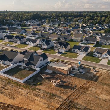 A suburban neighborhood with houses and a construction site in the foreground.