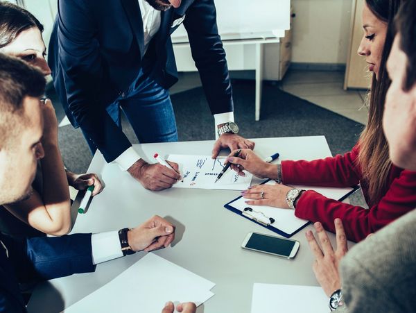 A team collaborating on a project around a table with notes and a smartphone.