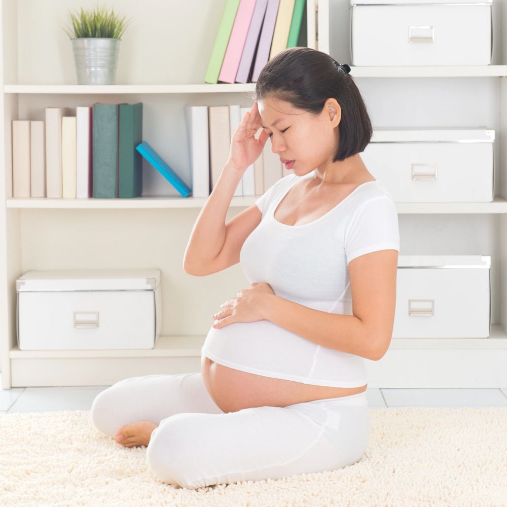 Pregnant woman sitting on the floor, holding her belly and head in discomfort.empowering pregnancy journey
expecting mothers support
personalized pregnancy care
