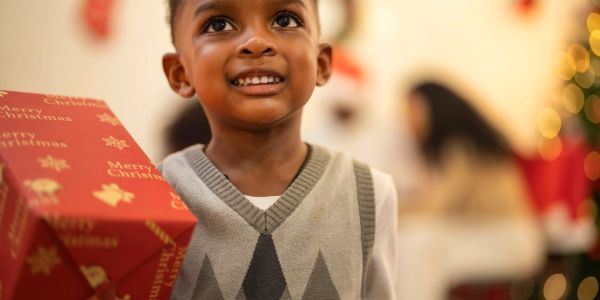 Smiling boy holding a Christmas gift.