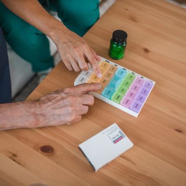 Caregiver assisting a senior woman with medication reminders