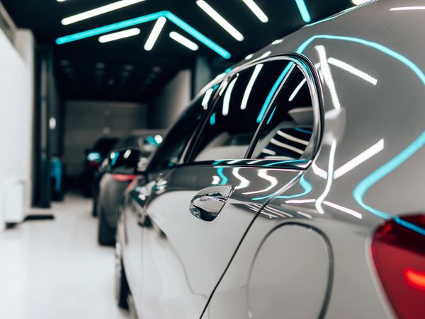 Shiny cars lined up in a modern, well-lit showroom.