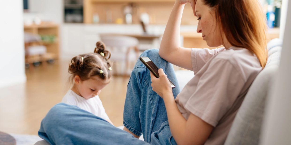 Mother looking stressed while child plays.