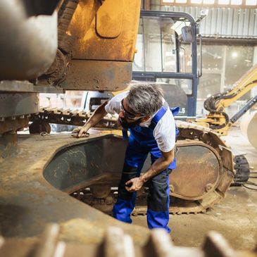 Mechanic working on heavy machinery in a workshop.