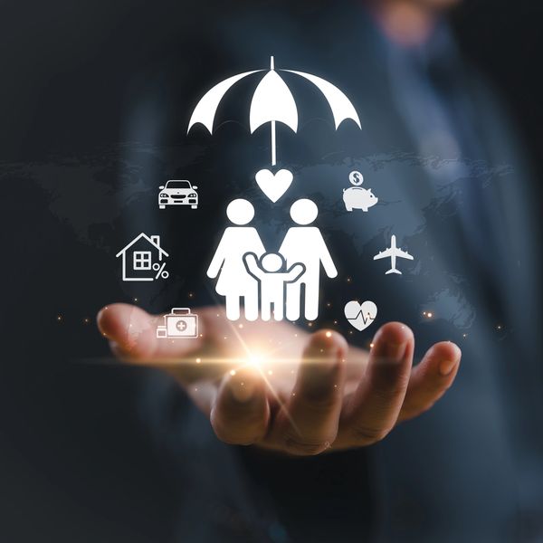 A hand holding icons symbolizing family protection and insurance coverage.