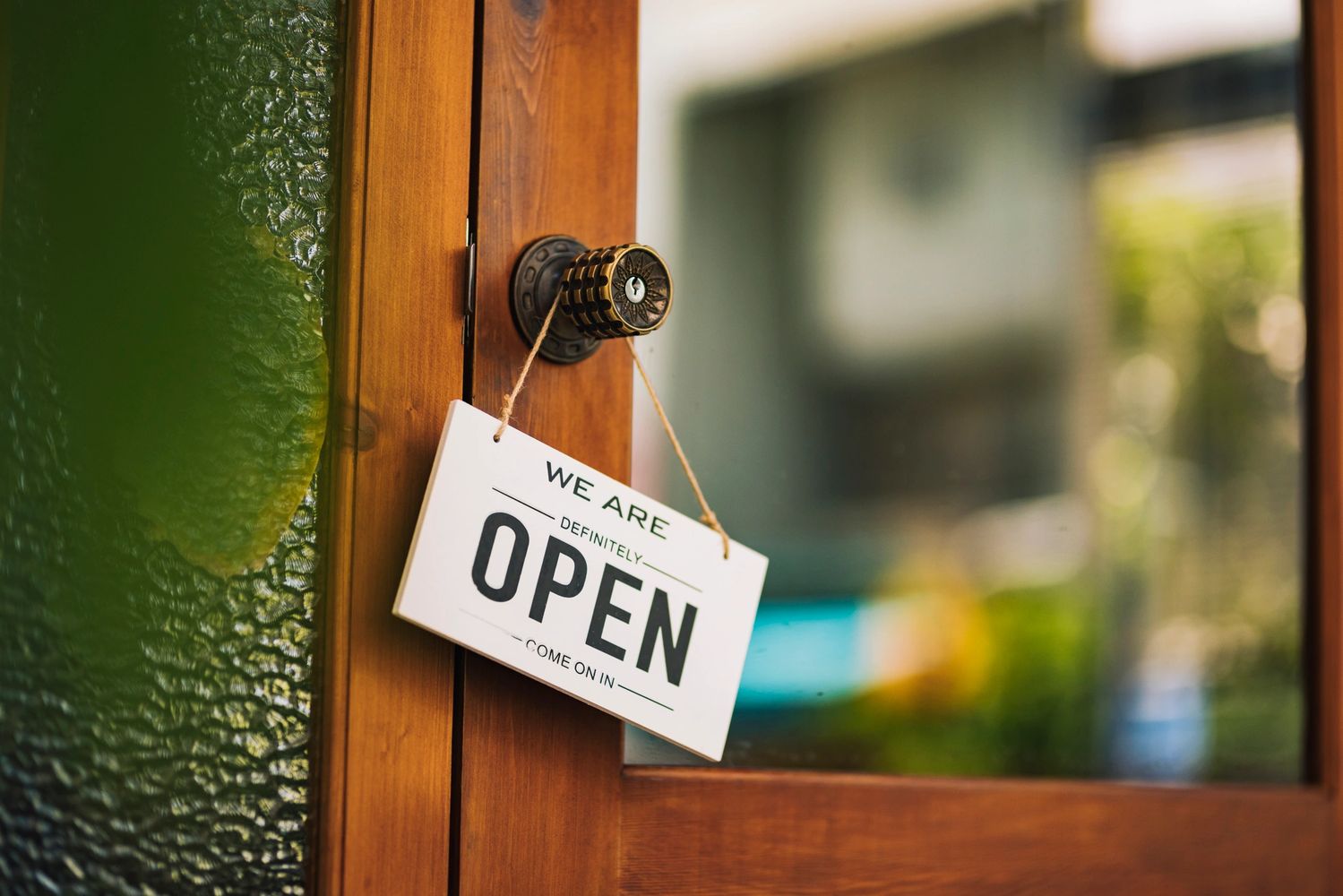 Door sign hanging on a knob indicating the place is open.