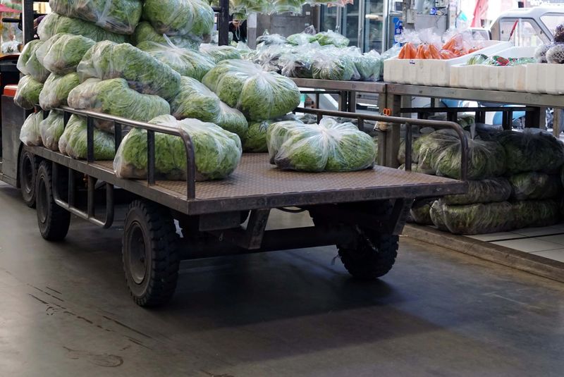 A worker loading a products vegetables into a truck in the wholesale market.