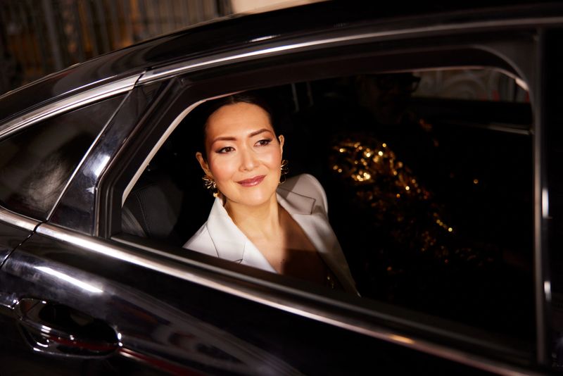 The actress gazes at the crowd through the limousine window at the event's arrival.