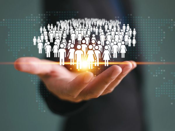 Hand holding digital human icons representing global population.