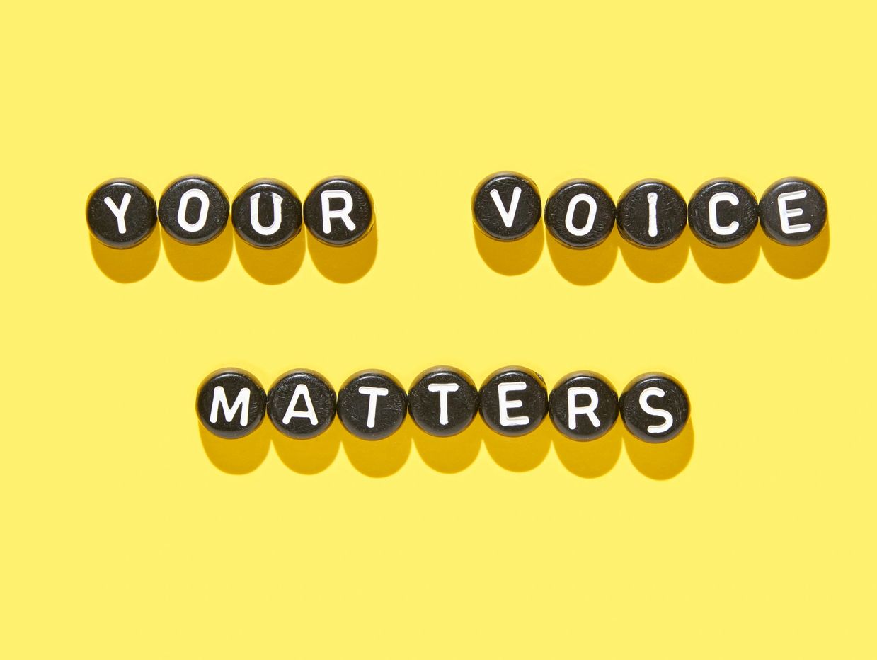 Black lettered buttons spell "YOUR VOICE MATTERS" on yellow background.