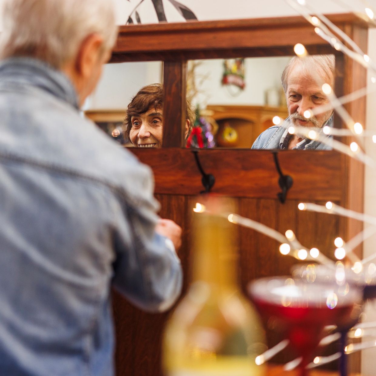 Elderly couple reflected in a wooden mirror, sharing a quiet moment together.