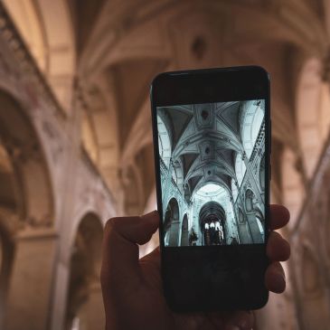 Person capturing ornate cathedral ceiling on phone.