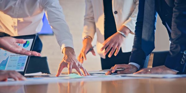 Business team collaborating over documents and data on a table in an office.