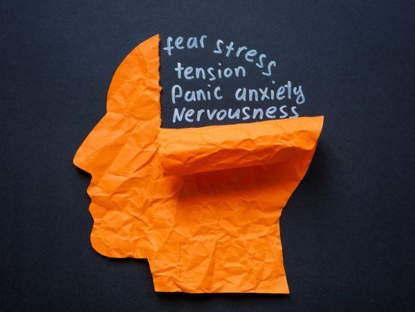 Crumpled paper head with words of anxiety and stress.