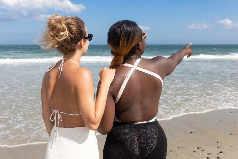 Girlfriends looking at view on the beach