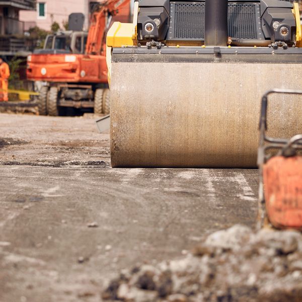 Close-up of a road roller compacting asphalt on a construction site.