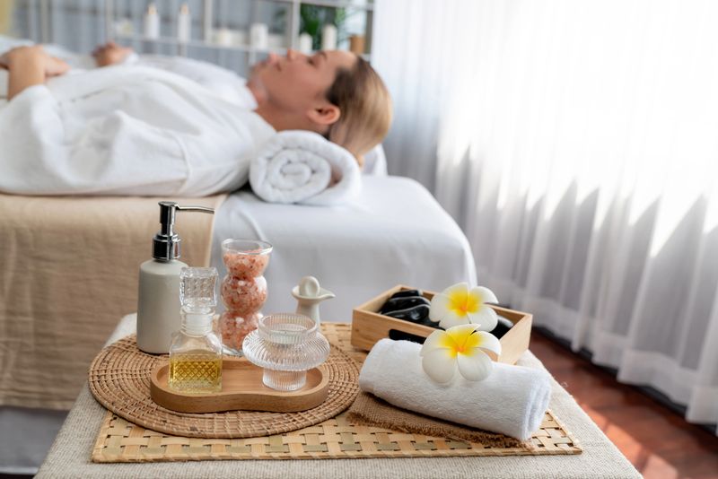 Aromatherapy massage on daylight ambiance or spa salon composition setup with focus decor and spa accessories on blur woman enjoying blissful aroma spa massage in resort or hotel background. Quiescent