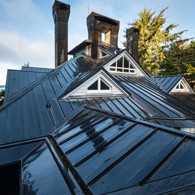 Complex residential metal roof design with multiple dromers, chimney and angles