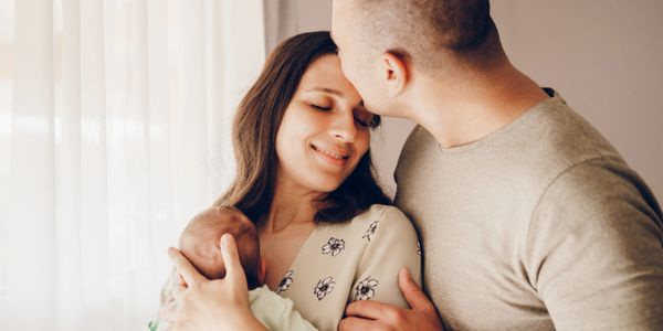 A tender moment of parents embracing their baby with love.