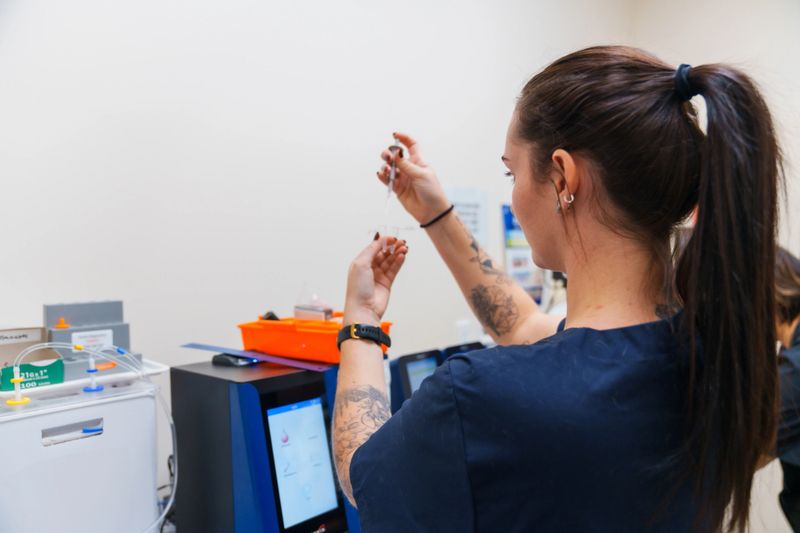 Lab Technician woman  conducting research dripping test liquid into test tube in a modern laboratory.