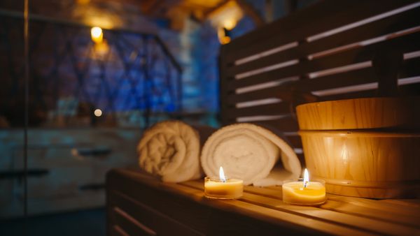Spa scene with towels, candles, and wooden bowls.