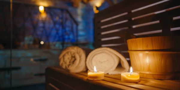 Spa scene with towels, candles, and wooden bowls.