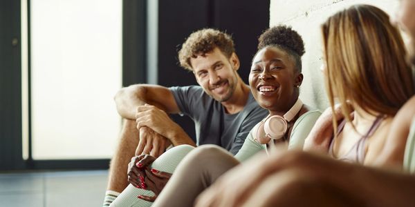 A group of friends sitting and happily chatting indoors.
