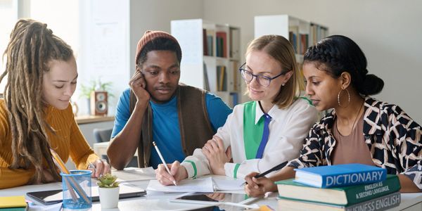 Group of diverse young adults studying together at a table.
