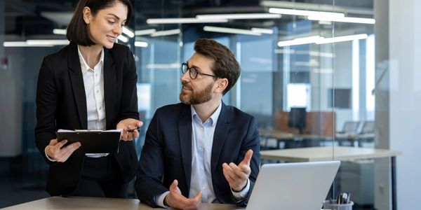Two business colleagues discussing work in a modern office.
