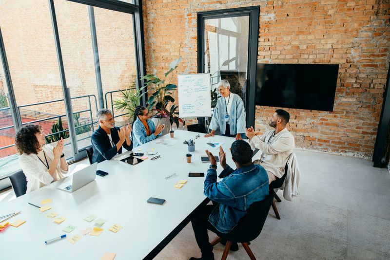 Successful business colleagues gather in a modern setting for a productive meeting, engaging in teamwork and collaboration to drive innovation and ideas.