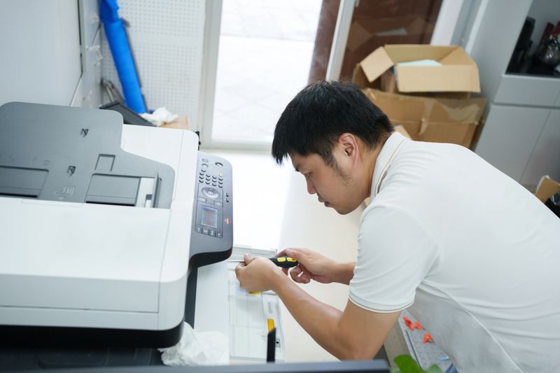 Asian man repairing printer