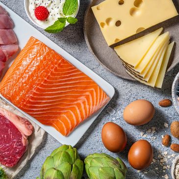A variety of protein-rich foods including meat, fish, cheese, eggs, nuts, and beans.